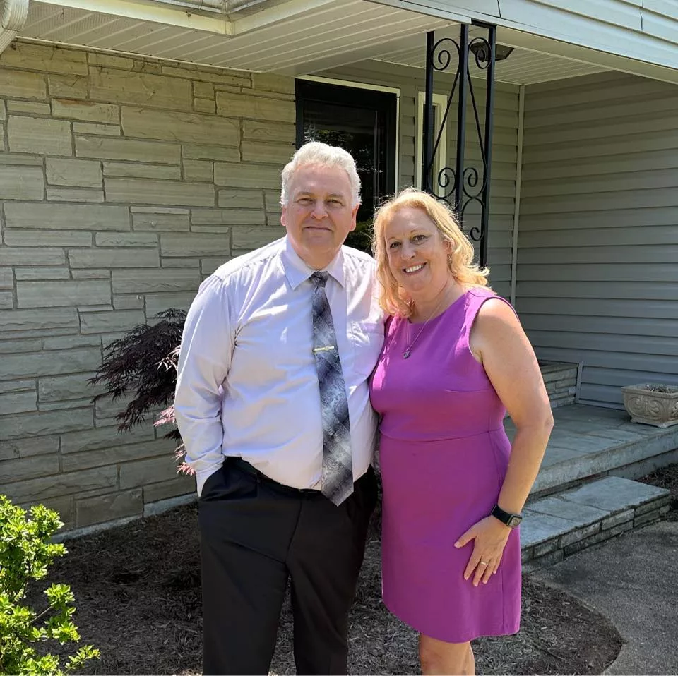 Fred Zickefoose pastor standing outside with wife